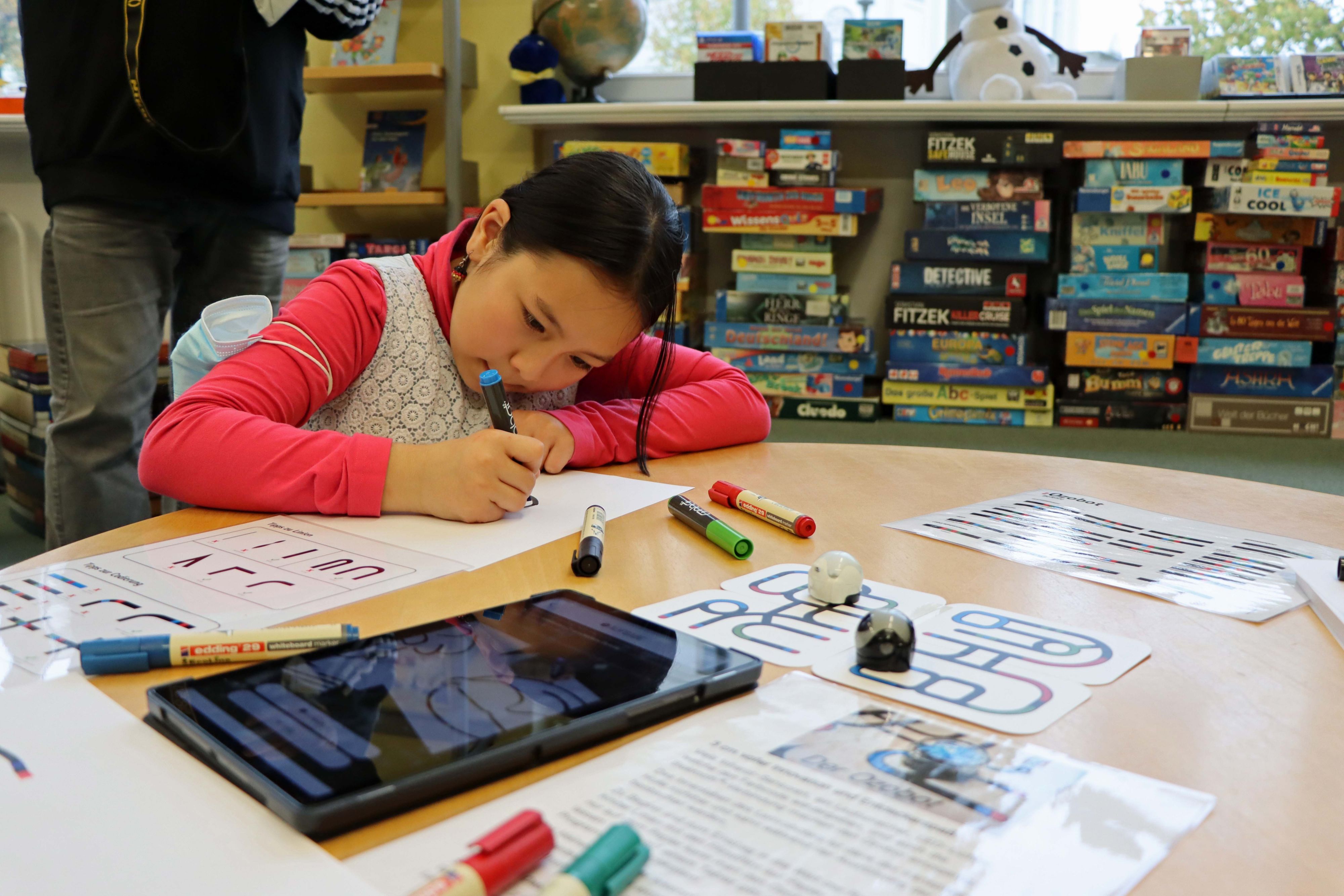 Mädchen probiert die programmierbaren Farbroboter Ozobot aus / Foto: C. Heinkel