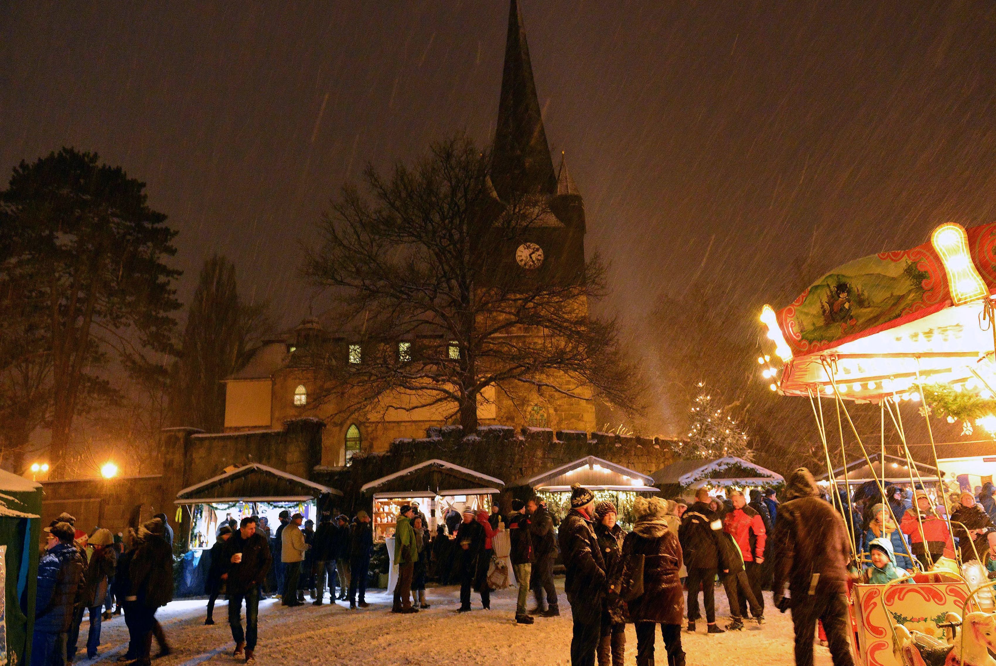 Ein verschneiter Weihnachtsmarkt in Oberlind. Es ist Abend.
